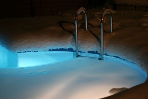 Beleuchtetes Becken in winterlicher Nacht - ganzjähriger Service